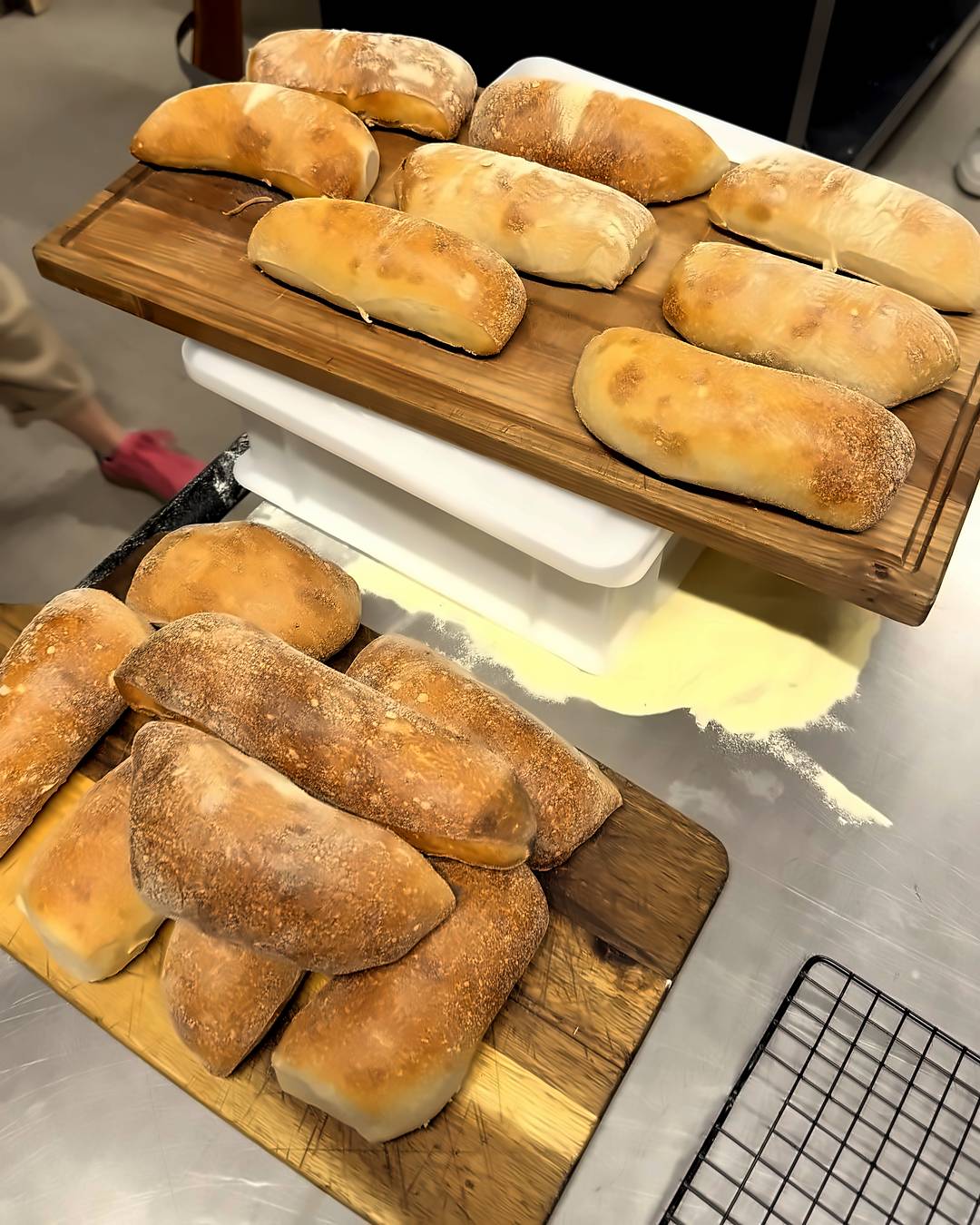 Frisch gebackene Ciabatta Weckerl aus dem Holzbackofen auf Holzbrettern in der Backstube im Pizzakurs